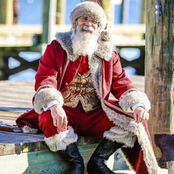 Santa sitting on a dock.